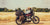 Biker sleeping on retro motorcycle with soft saddlebags.