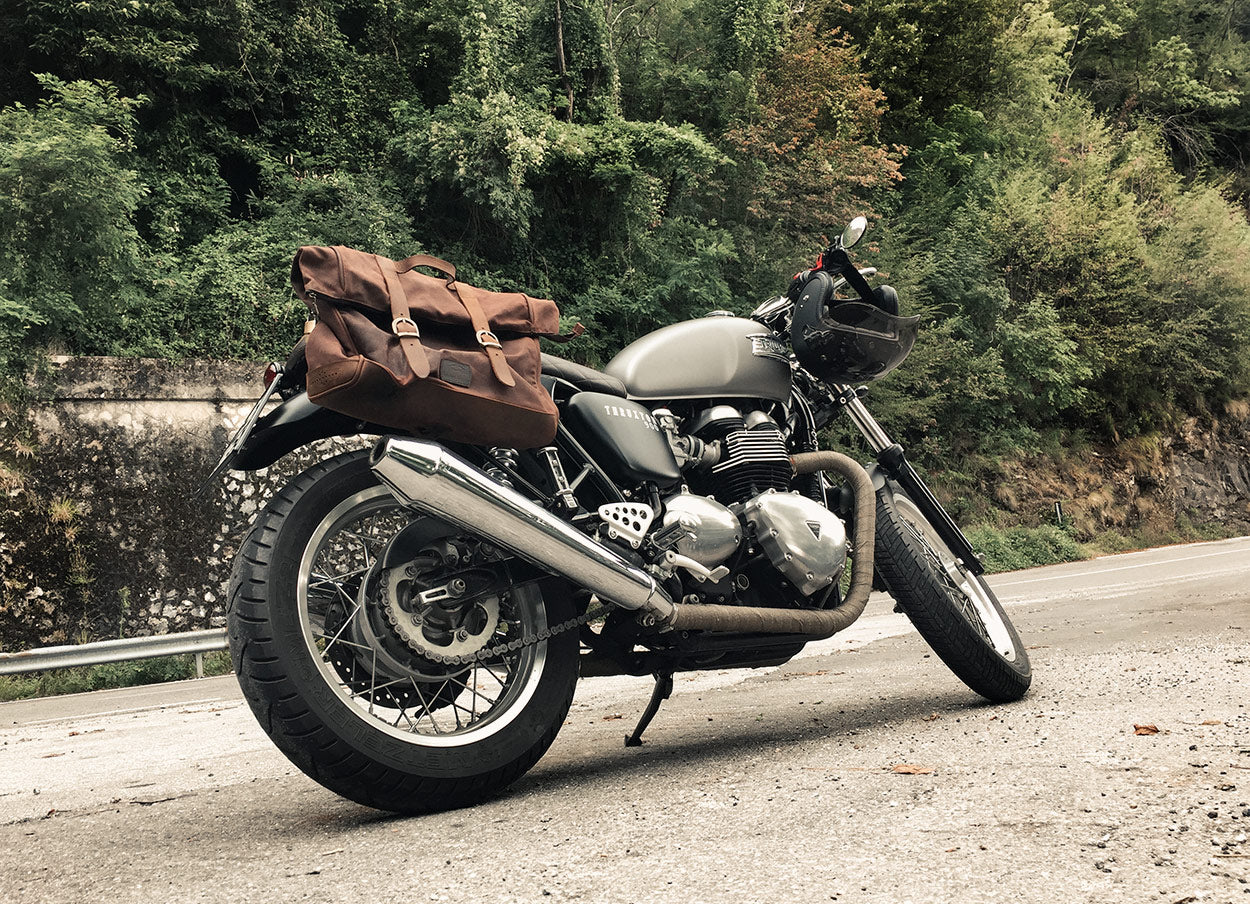 Thruxton 900 on the road with large Saddlebags.
