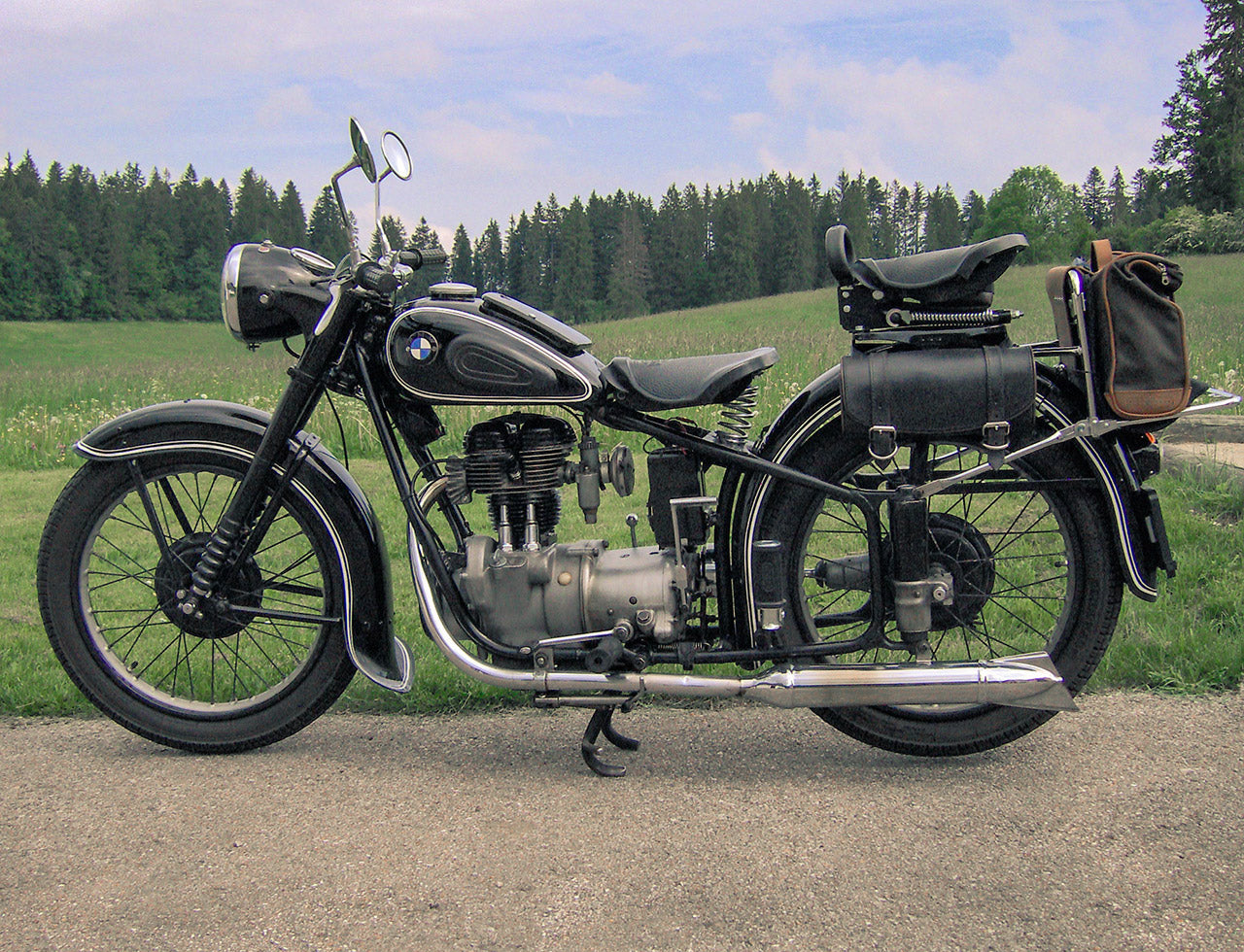 Vintage BMW motorcycle with soft luggage on rear rack.