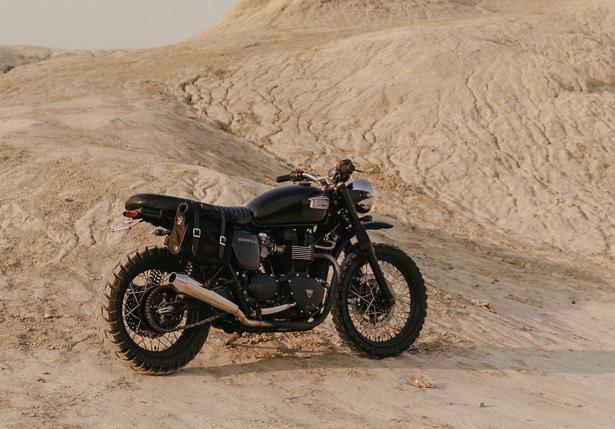 Custom black Bonneville with sporty exhausts and vintage saddlebags.